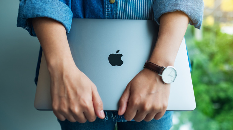 Person holds MacBook Pro