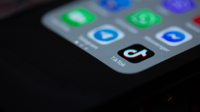 A close-up photograph of the TikTok icon on a smartphone.