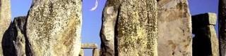 Stonehenge with a new moon seen through standing stones