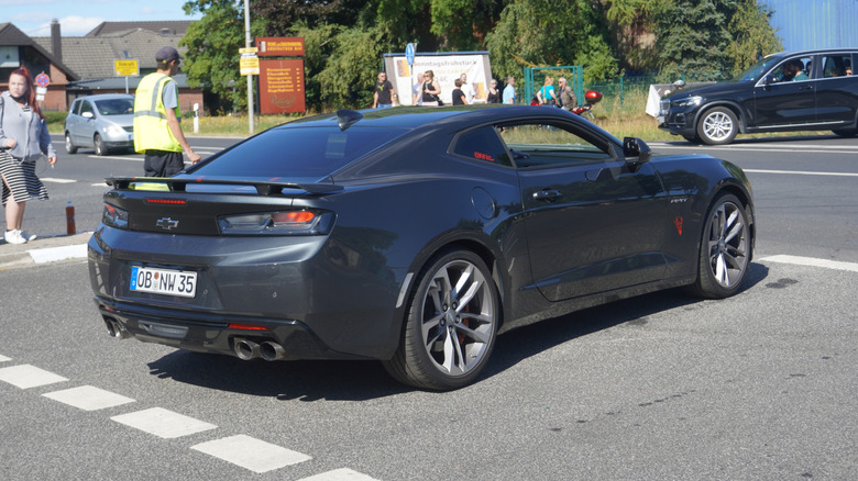 A gray European spec 2016 Chevy Camaro, rear 3/4 view, German license plates