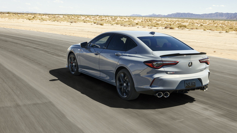 2024 Acura TLX driving on racetrack, rear-left view