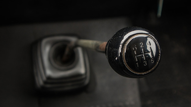 An old manual transmission floor shifter, likely from a pickup truck, up close