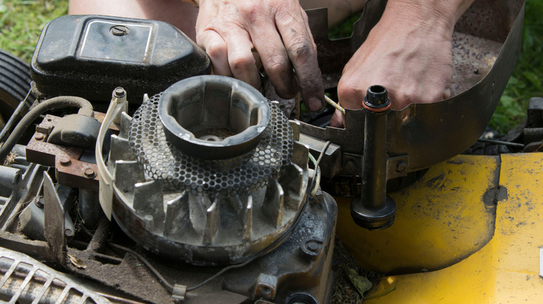 A man working on a lawn mower engine