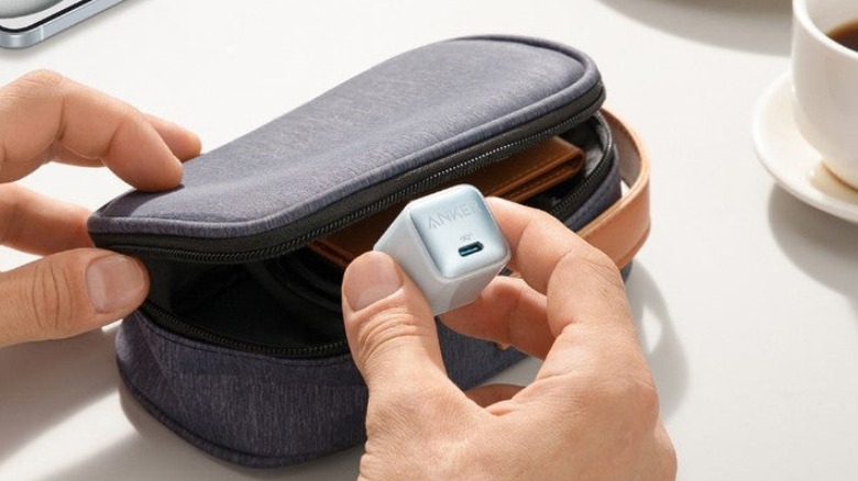 Person putting an Anker charger into a carrying case