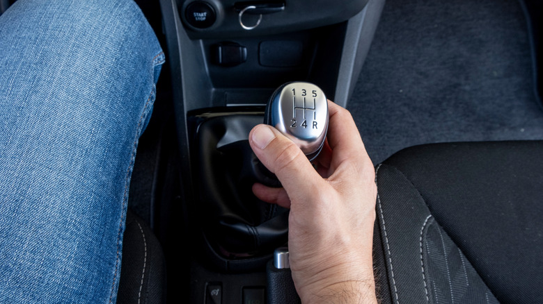 Person shifting gears in manual car