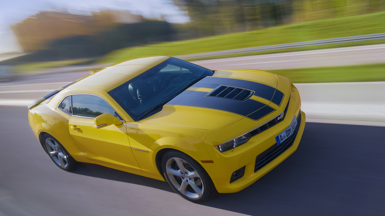 Chevrolet Camaro driving at-speed on highway, front-right view