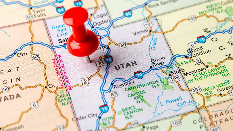 Close up of a USA map showing Utah with a red drawing pin pushed into the state