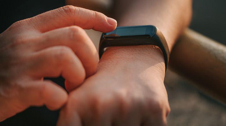 A person using a fitness tracker on their wrist