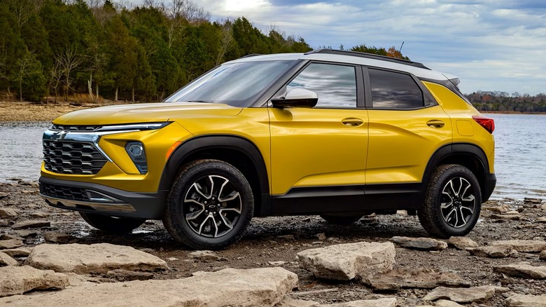 Chevrolet Trailblazer parked on a rugged off-road surface with trees and a body of water in the background