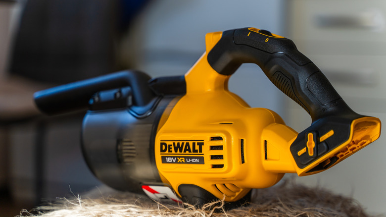 DeWalt hand vacuum sitting on bale of hay