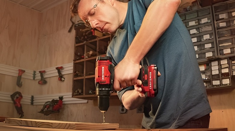 Man using Craftsman drill on a plank of wood
