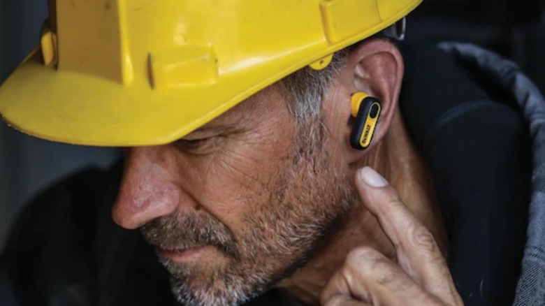 A worker wearing DeWalt jobsite-pro x1 earbuds