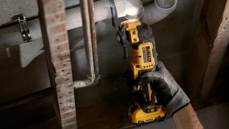 Person using DeWalt Multi-tool to cut PVC