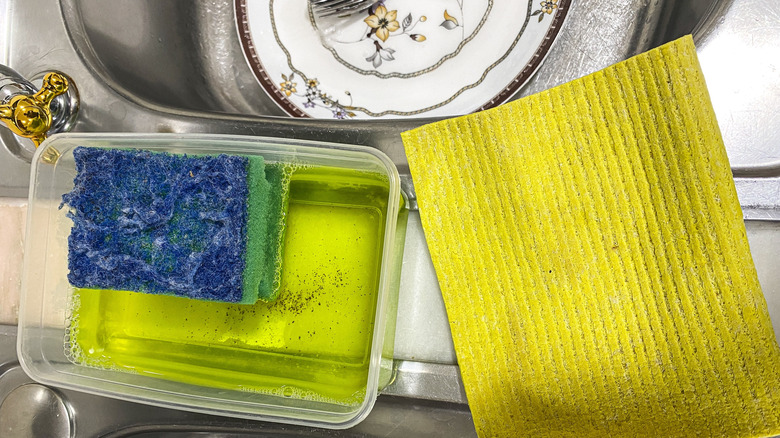 Dirty scrub cloth and sponge on edge of dish sink