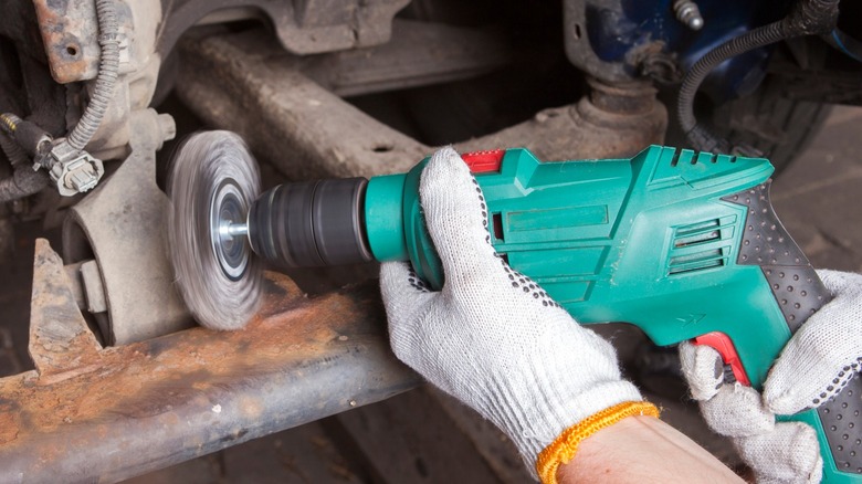 Man using drill with cleaning attachment