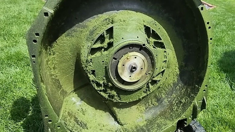 An Ego lawn mower deck covered in grass. and mulch