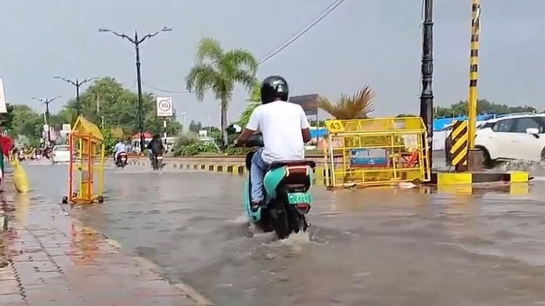 Man driving electric moped in flooded street