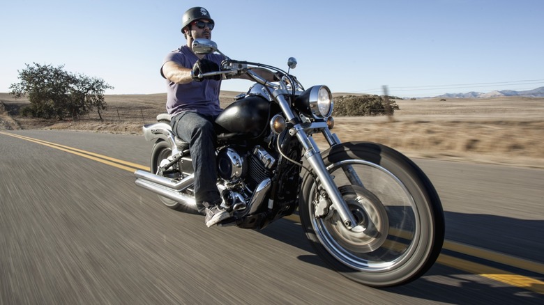 A man riding a cruiser motorcycle