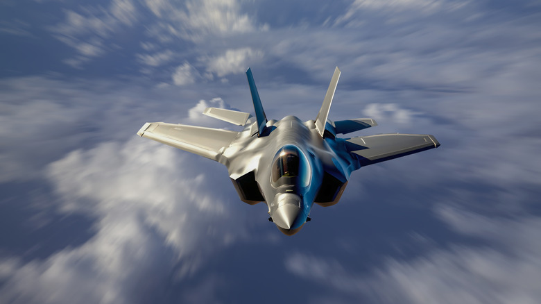 Fighter jet flying over clouds