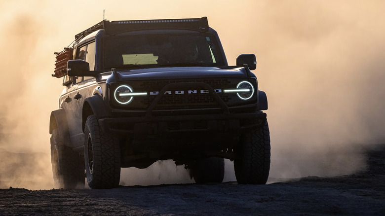 A Ford Bronco off-roading with a dust cloud behind it