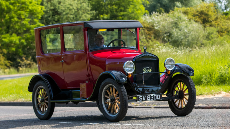 Man in red Ford Model T on country road