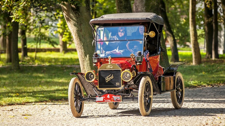 Red Ford Model T with parade bunting on cobbled road