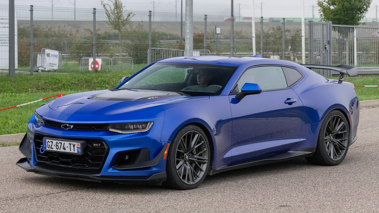 Front 3/4 view of blue Chevy Camaro ZL1 driving on rural road.
