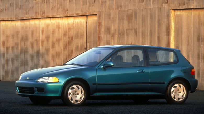 Green 1993 Honda Civic hatchback equipped with four-cylinder engine in front of a building.