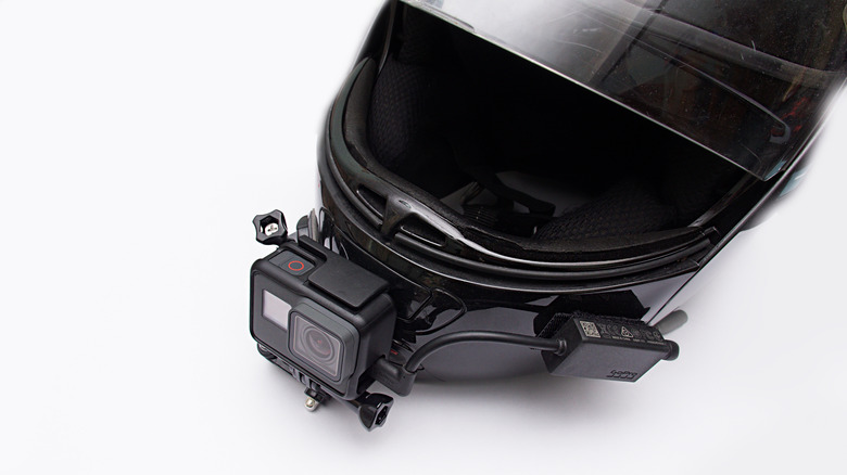 Motorcycle helmet with motovlog set-up consisting of GoPro camera mounted on chin and microphone adapter to side.