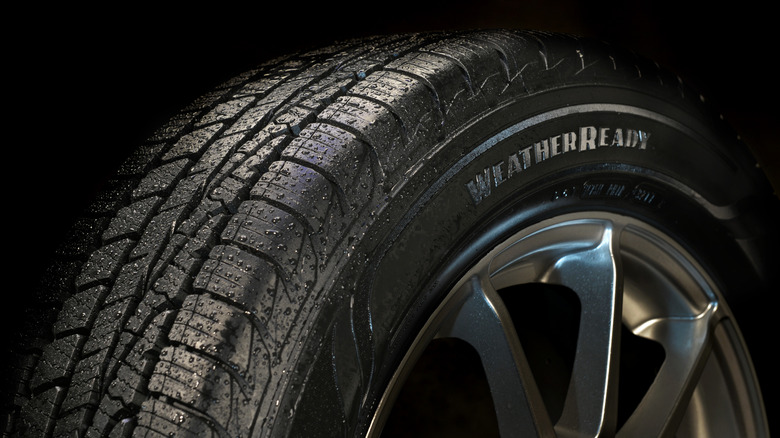 Goodyear Assurance tire in studio setting with water droplets