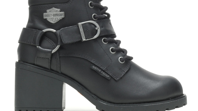 A close-up of a lace-up riding boot with high heels and chunky tread.