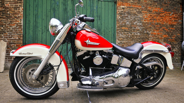 Red Harley-Davidson Softail parked in front of brick wall