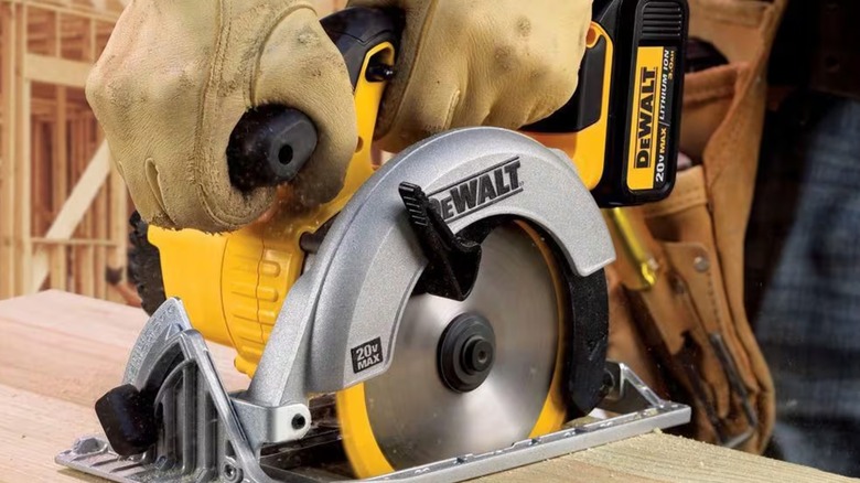 A person using a DeWalt 20V MAX circular saw