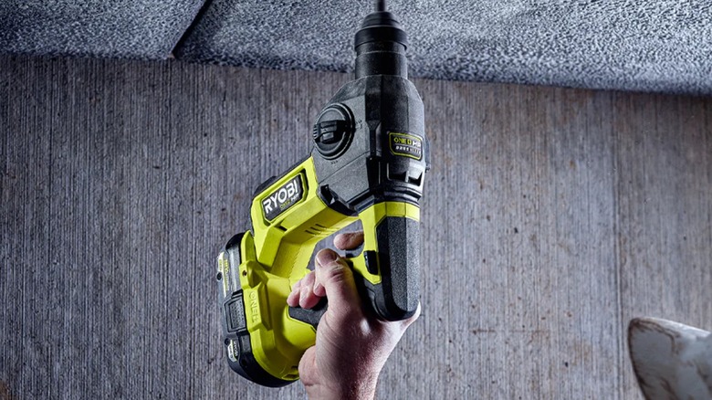 A person using a Ryobi 18V ONE+ rotary hammer