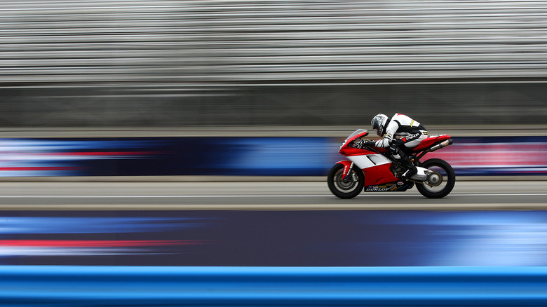A man riding a sportbike at high speed on a racetrack