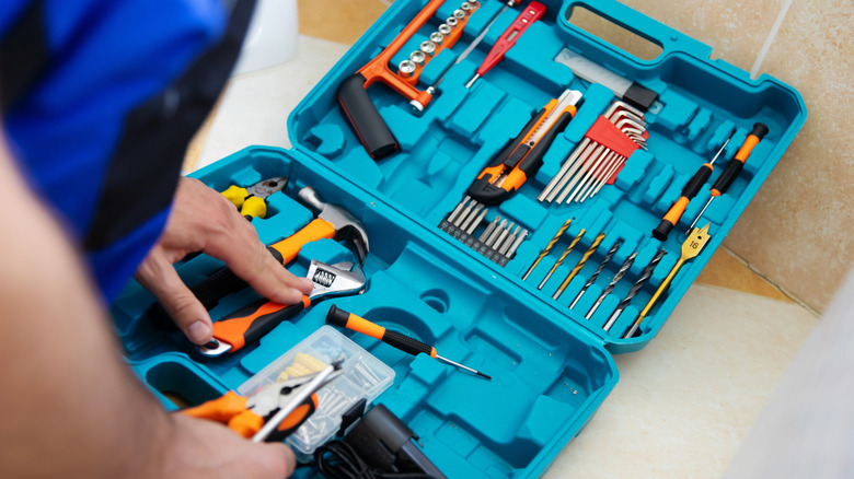 A person looking through a tool kit.