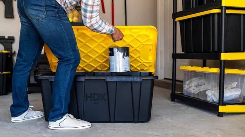 a person using a home depot hdx plastic storage container