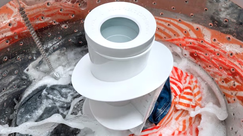 A close-up of clothes being washed in a Hotpoint washing machine