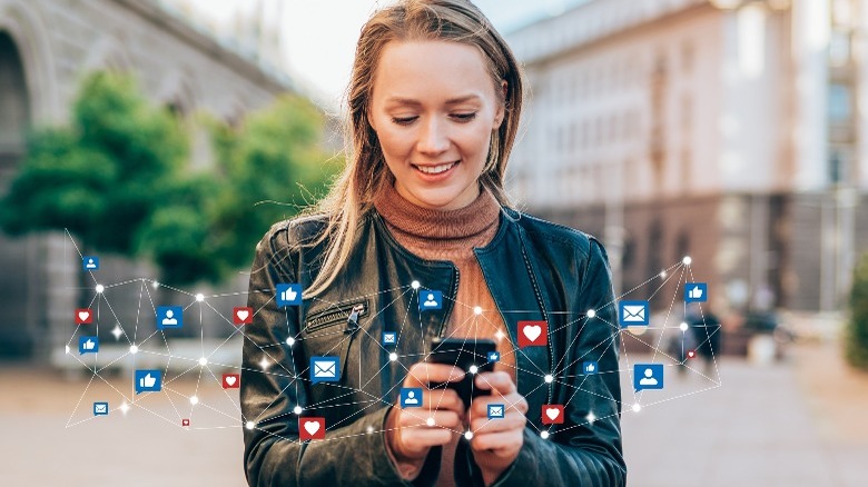 A woman using a smartphone with apps floating around her