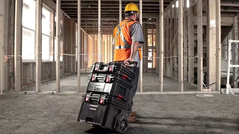 Man rolling Husky Build-Out boxes around work site