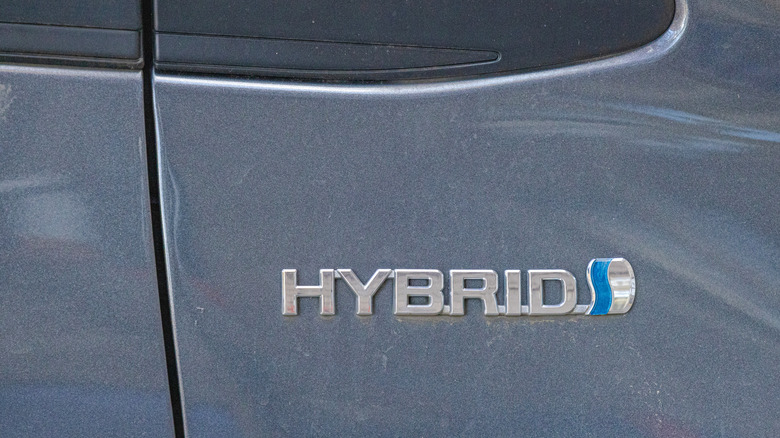 A Hybrid badge on the back of an unidentified gray Toyota