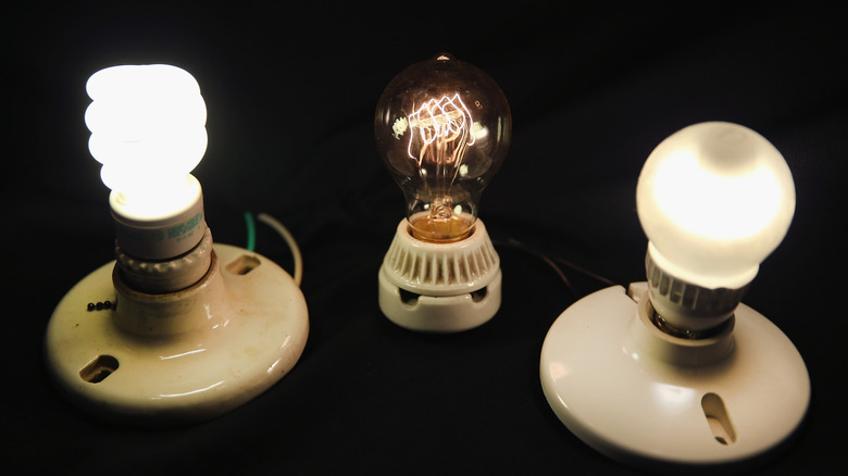 A vintage-style incandescent light bulb (C) is shown with an LED light bulb (R) and a compact florescent (CFL) light bulb