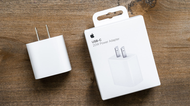 iPhone 20 Watt charger and its display box on a wooden surface