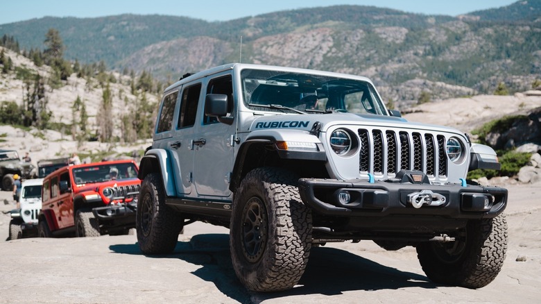 A line of Jeep Wranglers climb rocky terrain on the Rubicon Trail in California.