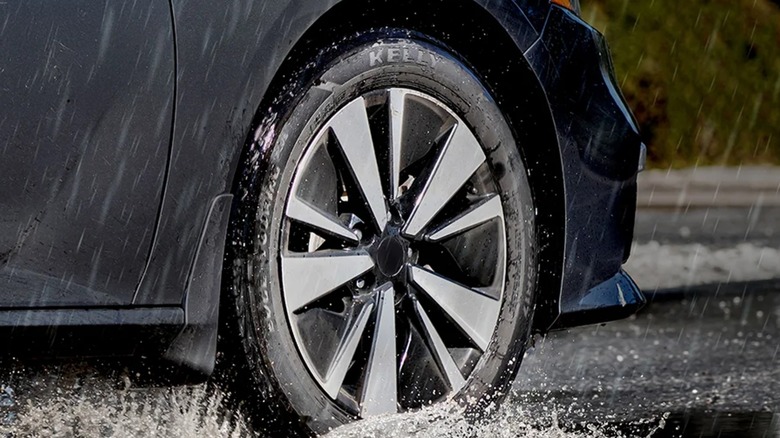 Close up of a car driving through rainy weather equipped with a Kelly tire.