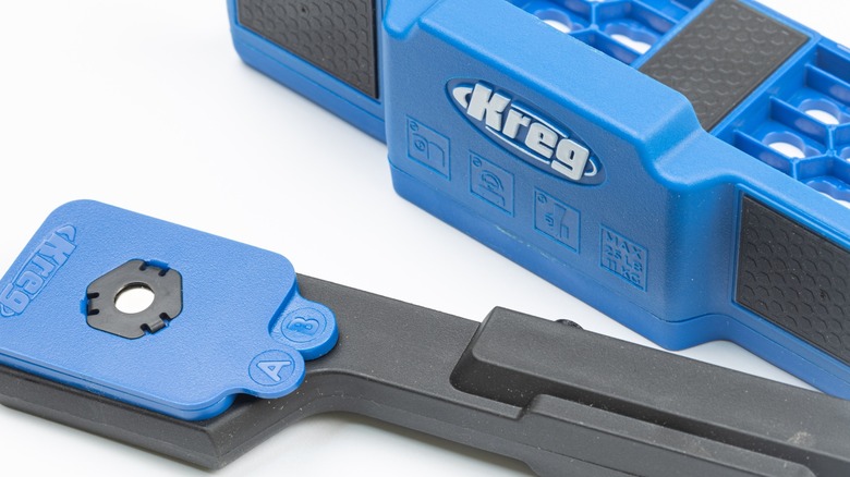 Blue and black Kreg clamp against a white background