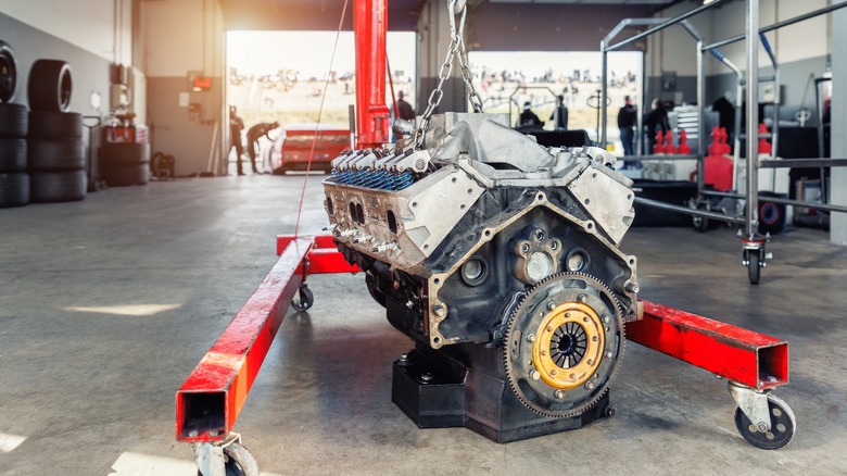 NASCAR V8 engine on hoist in garage. NASCAR V8s use cast-iron magnesium alloy block construction