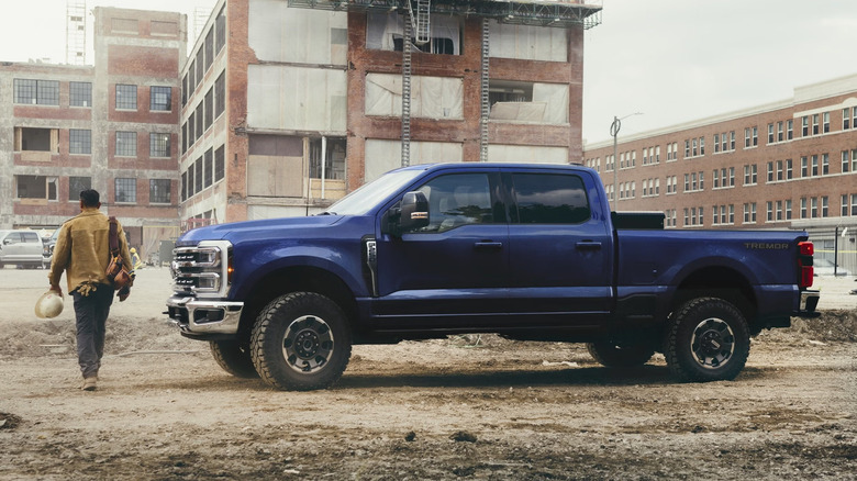 A man passes by a blue Ford Super Heavy Duty