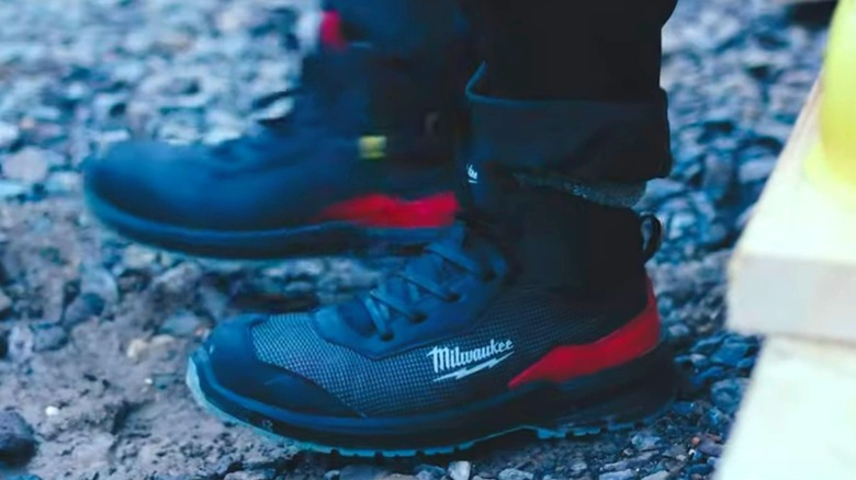 A person wearing Milwaukee boots on stone.