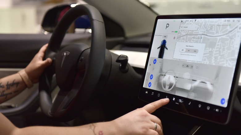Person using Tesla Model 3 interior screen